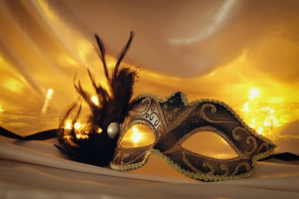 Bilden av elegant venetiansk mask över guld silke bakgrund. — Stockfoto