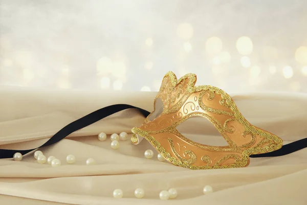 Bild der eleganten venezianischen Goldmaske über zartem Seidenstoff Hintergrund. — Stockfoto