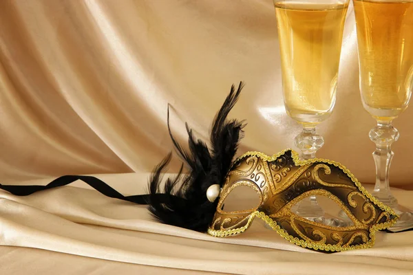 Image of elegant venetian mask and glasses of champagne over gol — Stock Photo, Image