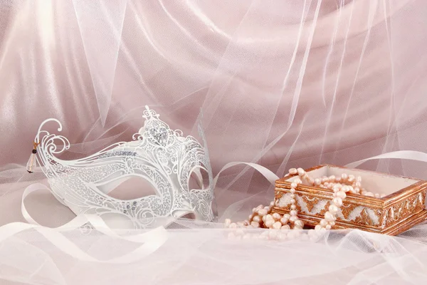 Image of delicate and elegant white venetian mask in front of tulle background. — Stock Photo, Image