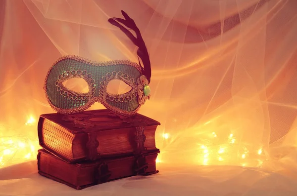 Bild einer eleganten venezianischen Maske über alten Büchern vor Tüll-Hintergrund. — Stockfoto