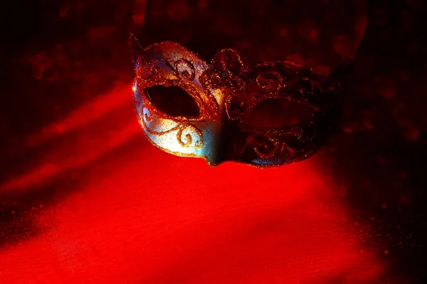 Obrázek elegantní modré a zlaté benátské, mardi gras maska červené pozadí. Kouzelný lesk ovrlay. — Stock fotografie