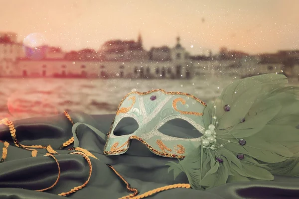 Image of elegant venetian mask on silk fabric in front of blurry Venice background. — Stock Photo, Image