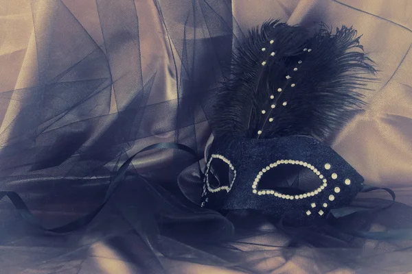 Immagine di elegante maschera veneziana nera drammatica su sfondo tulle . — Foto Stock