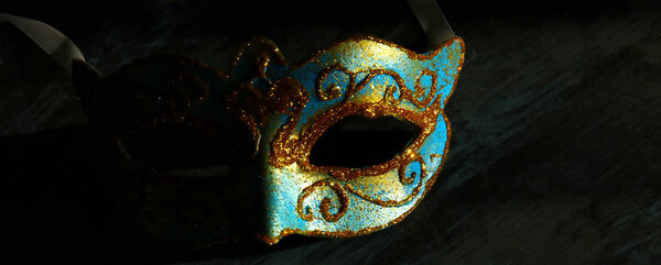 Изображение элегантной сине-золотой венецианской маски Марди Гра на черном фоне
.