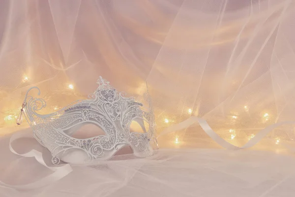 Image of delicate and elegant white venetian mask in front of tulle background. — Stock Photo, Image