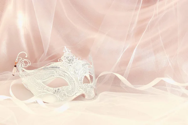 Image of delicate and elegant white venetian mask in front of tulle background. — Stock Photo, Image