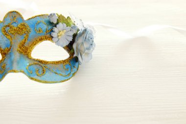 Hassas mavi zarif Venedik Maske üzerinde ahşap beyaz arka plan görüntüsü. Seçici odak.