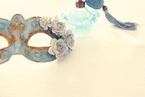 Afbeelding van delicate blauwe elegante Venetiaanse masker over houten witte achtergrond. Selectieve aandacht. — Stockfoto
