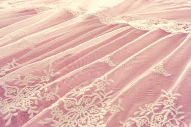 Arka plan beyaz hassas dantel kumaş pembe bir arka plan üzerinde.