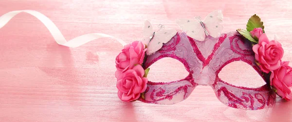 Afbeelding van fijne elegante Venetiaanse masker over houten roze achtergrond. Selectieve aandacht. — Stockfoto