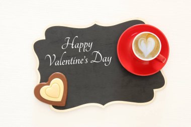 Sevgililer günü arka plan. Kırmızı fincan kahve kalp şekli köpük ve çikolata ile. Üstten Görünüm görüntü.