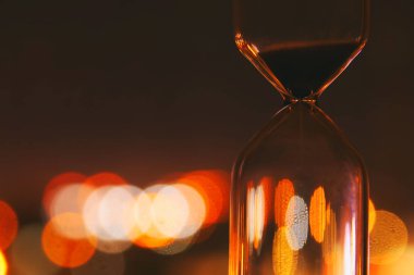 Kum saati bokeh şehir ışıkları üzerinde zaman geçen kavram olarak iş son tarih için.