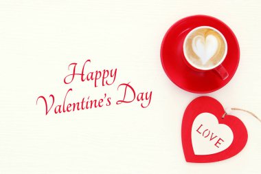 Sevgililer günü arka plan. Kırmızı fincan kahve kalp şekli köpük ve çikolata ile. Üstten Görünüm görüntü.