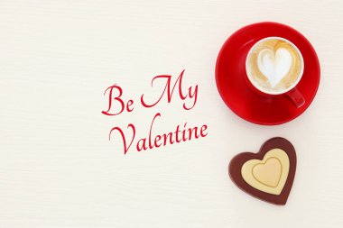 Sevgililer günü arka plan. Kırmızı fincan kahve kalp şekli köpük ve çikolata ile. Üstten Görünüm görüntü.