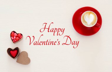 Sevgililer günü arka plan. Kırmızı fincan kahve kalp şekli köpük ve çikolata ile. Üstten Görünüm görüntü.