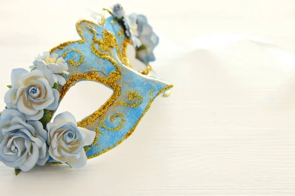 Зображення ніжно-блакитної витонченої венеціанської маски на дерев'яному білому тлі. Вибірковий фокус . — стокове фото