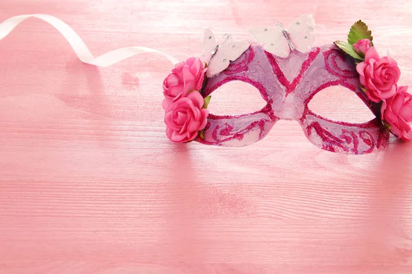 Afbeelding van fijne elegante Venetiaanse masker over houten roze achtergrond. Selectieve aandacht. — Stockfoto