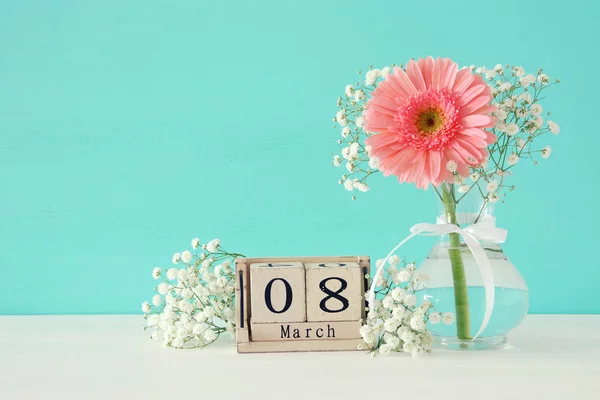 Nemzetközi női nap koncepció gyönyörű virág a vázában a fából készült asztal képe. — Stock Fotó