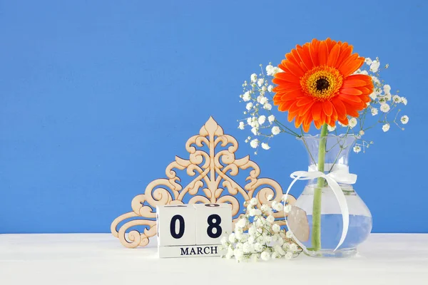 Image of International women day concept with beautiful flower in the vase on wooden table.