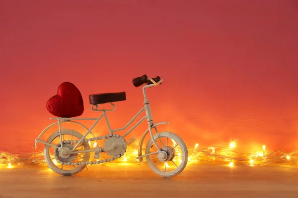 San Valentino romantico sfondo con bianco vintage bicicletta giocattolo e cuore su di esso sopra tavolo di legno . — Foto Stock