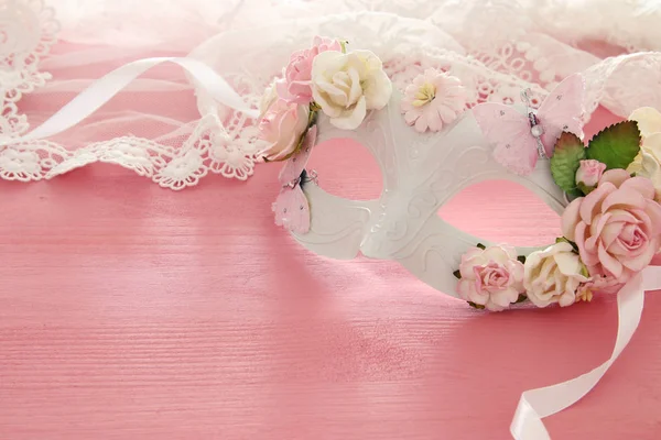 Imagen de delicada máscara veneciana elegante sobre fondo rosa de madera. Enfoque selectivo . —  Fotos de Stock