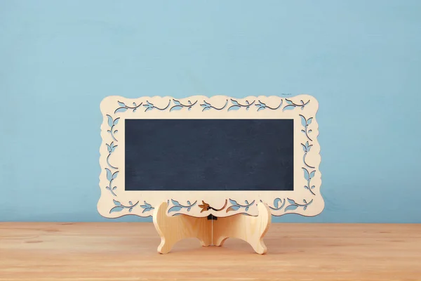 Empty vintage blackboard on wooden table. — Stock Photo, Image