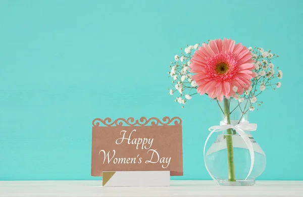 Imagen del concepto de día internacional de la mujer con hermosa flor en el jarrón en la mesa de madera . — Foto de Stock