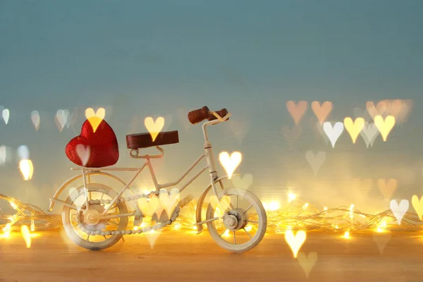 Aftelkalender voor Valentijnsdag romantische achtergrond met witte vintage fiets speelgoed en hart daarop over houten tafel. — Stockfoto