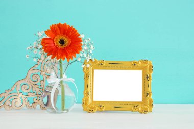 Güzel buket bahar yanındaki boş vintage fotoğraf çerçeve ahşap masa üzerinde görüntü. Fotoğraf montaj kadar sahte.