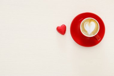 Sevgililer günü arka plan. Kırmızı fincan kahve kalp şekli köpük ve çikolata ile. Üstten Görünüm görüntü