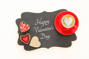 Sevgililer günü arka plan. Kırmızı fincan kahve kalp şekli köpük ve çikolata ile. Üstten Görünüm görüntü