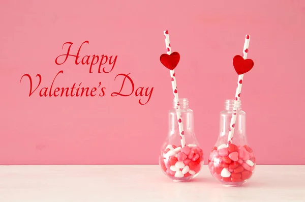 情人节浪漫的背景与塑料灯泡与心脏形状糖果和节日的灯在桌子上 — 图库照片