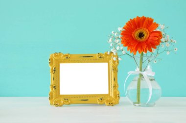 Güzel buket bahar yanındaki boş vintage fotoğraf çerçeve ahşap masa üzerinde görüntü. Fotoğraf montaj kadar sahte