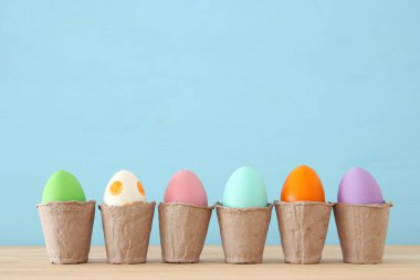 Mavi arka plan üzerinde renkli yumurta Paskalya Üstten Görünüm