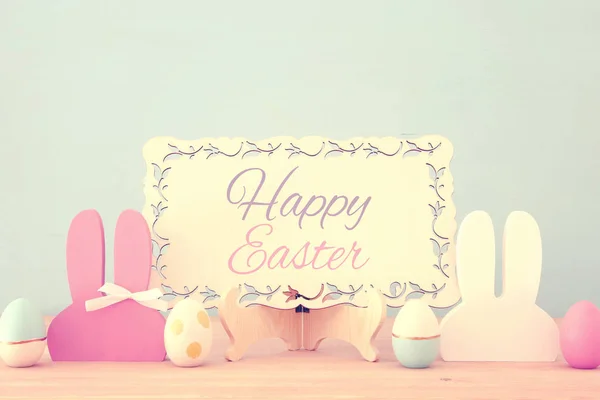 Lindas y coloridas orejas de conejo de madera y huevos de Pascua sobre mesa de madera . — Foto de Stock