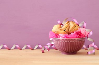 Purim kutlama kavramı (Yahudi karnaval tatil). Geleneksel hamantaschen Çerezler üzerinde ahşap masa.