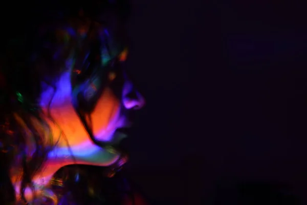 Abstraktes Porträt eines jungen Mädchens unter buntem Neonlicht, rätselhafter Stil. — Stockfoto
