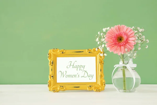 Imagen del concepto de día internacional de la mujer con hermosa flor en el jarrón en la mesa de madera . — Foto de Stock