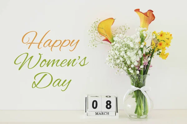 Έννοια ημέρα γυναίκας με όμορφα λουλούδια στο βάζο και ημερομηνία στο ξύλινο τραπέζι. — Φωτογραφία Αρχείου