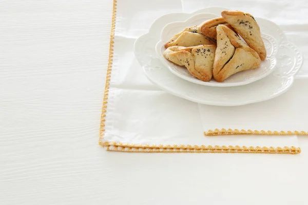 普庆祝概念 (犹太狂欢节假日)。传统 hamantaschen 曲奇饼在白色桌. — 图库照片