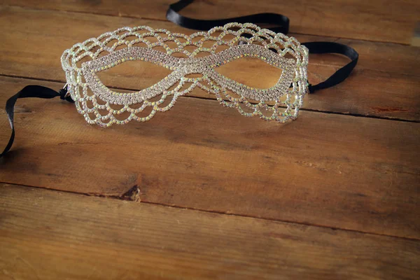 Image of beautiful diamond masquerade venetian mask over wooden vintage background. — Stock Photo, Image