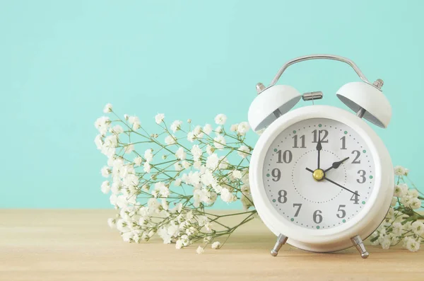 Imagen del cambio de hora de primavera. Concepto de verano. Reloj despertador Vintage sobre mesa de madera . — Foto de Stock