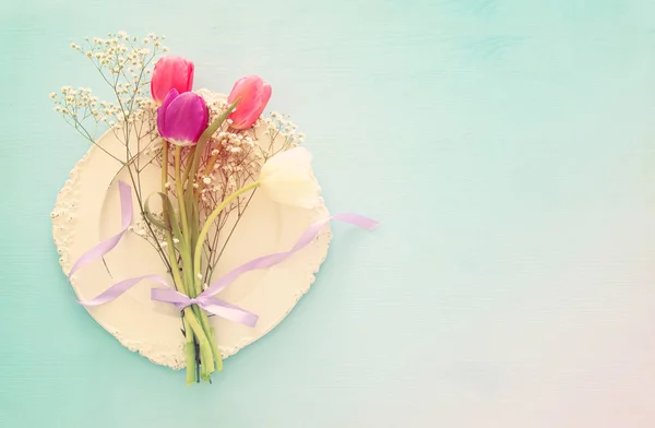 Bukett med rosa och vita tulpaner över pastell trä bakgrund. Ovanifrån. — Stockfoto