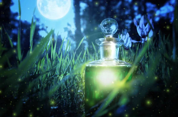 Magical fairy dust potion in bottle in the forest.