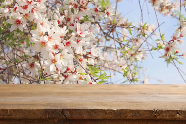 Rustika träbord framför våren körsbär blommar trädet. produkten visar och picknick koncept. — Stockfoto