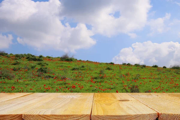 Деревянный деревенский стол перед полем красные маки. демонстрация продукции и концепция пикника . — стоковое фото