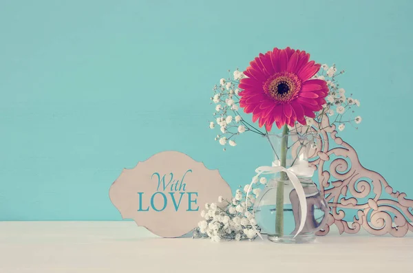 Image du concept de la Journée internationale de la femme avec une belle fleur dans le vase sur une table en bois . — Photo