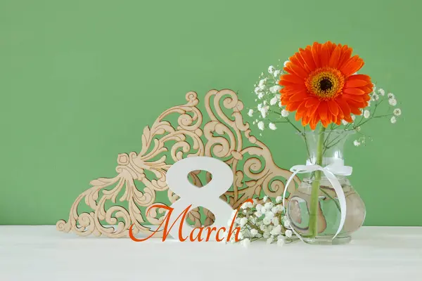 Image du concept de la Journée internationale de la femme avec une belle fleur dans le vase sur une table en bois . — Photo
