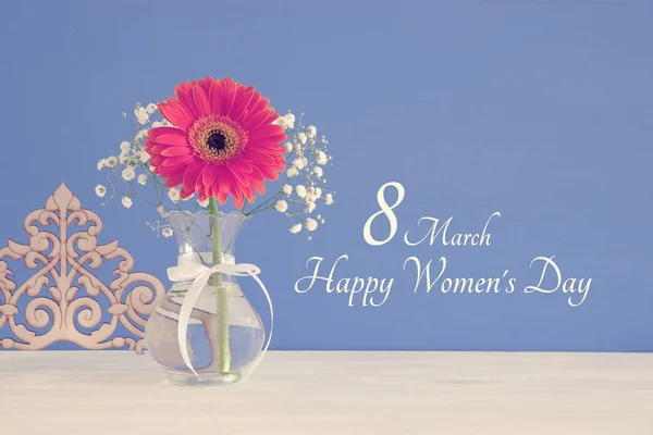 Imagen del concepto del Día Internacional de la Mujer con una hermosa flor en el jarrón sobre una mesa de madera . — Foto de Stock